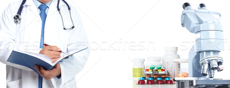 Doctor hands with microscope and pills. Stock photo © Kurhan