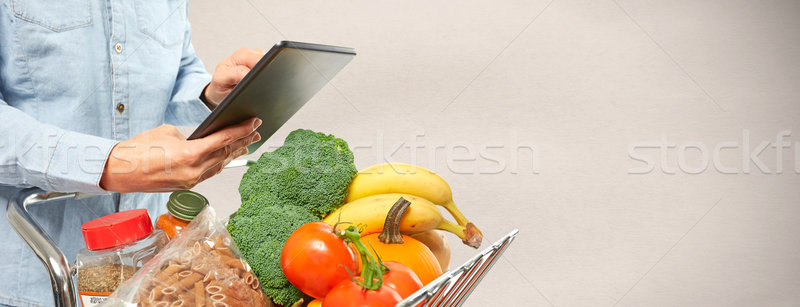 Woman with shopping cart and tablet computer. Stock photo © Kurhan