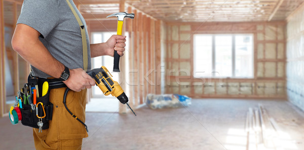 Builder handyman with drill and hammer. Stock photo © Kurhan