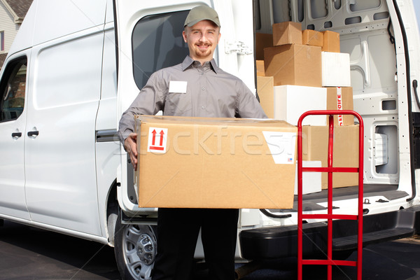 Young delivery man with parcel. Stock photo © Kurhan