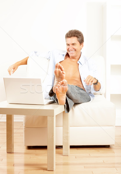 Człowiek laptop szczęśliwy uśmiechnięty domu pracy Zdjęcia stock © Kurhan