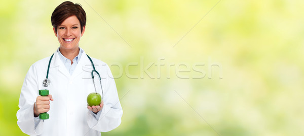 Doctor woman with dumbbell and apple. Stock photo © Kurhan