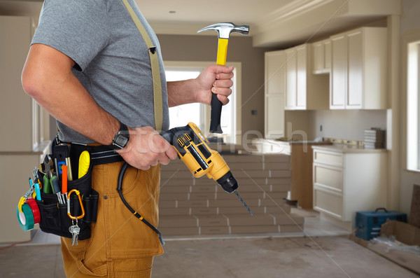 Builder handyman with drill and hammer. Stock photo © Kurhan