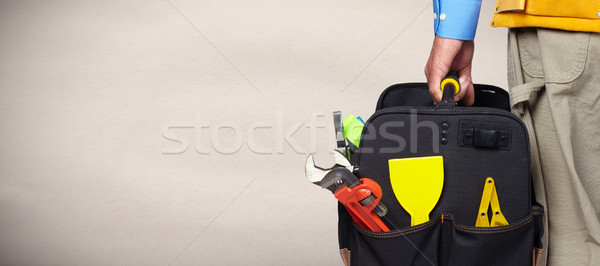 Hand of handyman with a tool bag. Stock photo © Kurhan