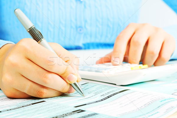 Stock photo: Hands with calculator.