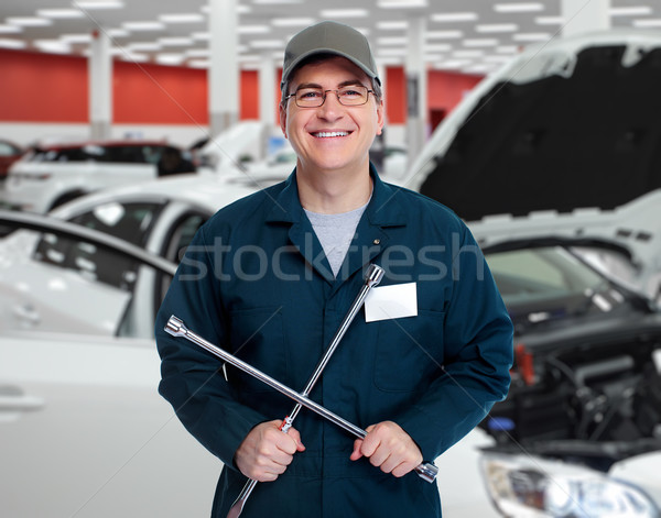 Auto mechanic with tire wrench in garage. Stock photo © Kurhan