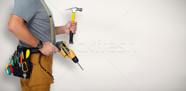 Builder handyman with drill and hammer. Stock photo © Kurhan