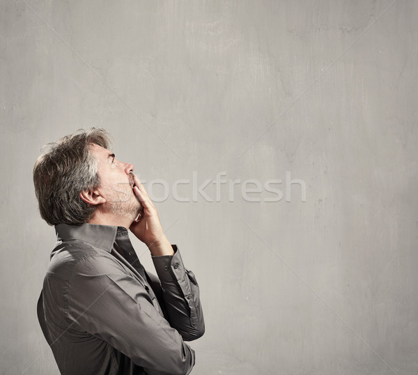 Gondolkodik férfi kaukázusi portré szürke fal Stock fotó © Kurhan