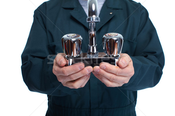Hands of plumber with water tap. Stock photo © Kurhan