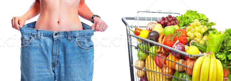 Slimming woman wearing big pants over white background. Stock photo © Kurhan