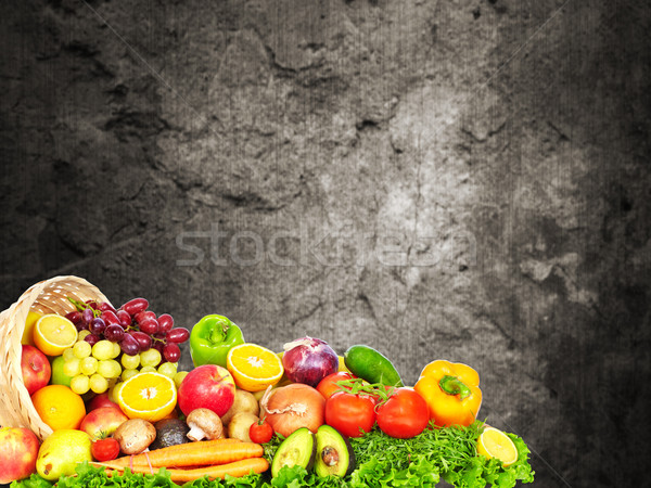 Vegetables and fruits over dark wall background. Stock photo © Kurhan