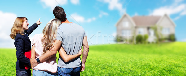 Real Estate agent woman with clients near new house. Stock photo © Kurhan