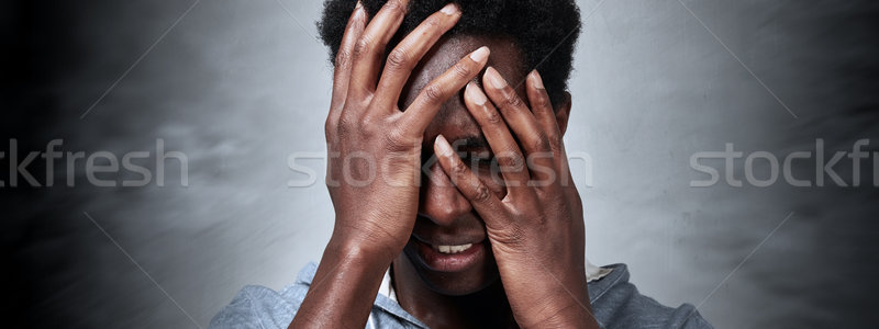 Dor de cabeça deprimido homem negro cinza parede mão Foto stock © Kurhan