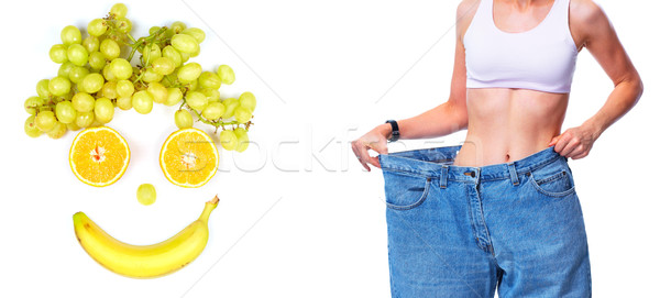 Slimming woman wearing big pants over white background. Stock photo © Kurhan