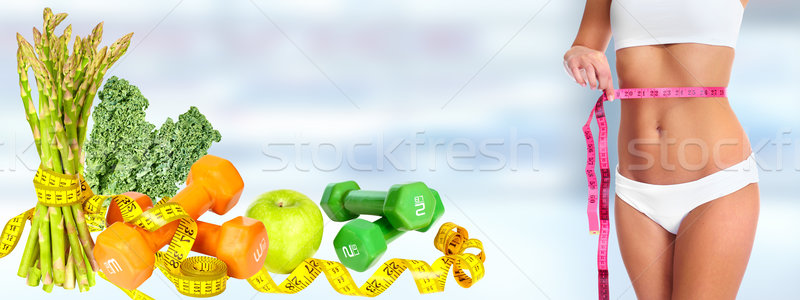 Woman waist with measuring tape over blue background. Stock photo © Kurhan