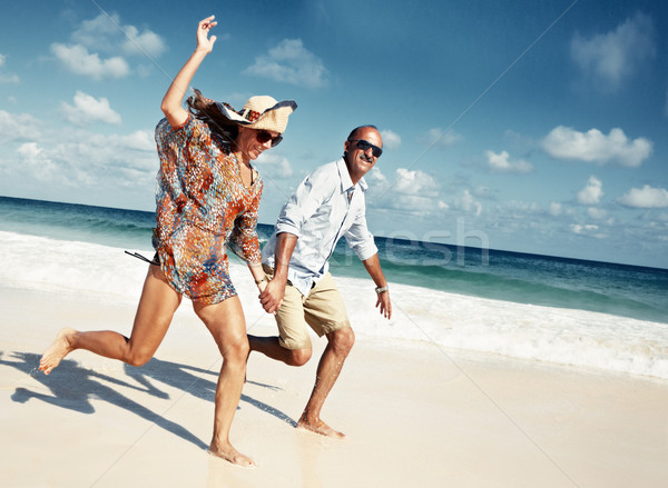 Stock photo: Happy couple running on the beach.