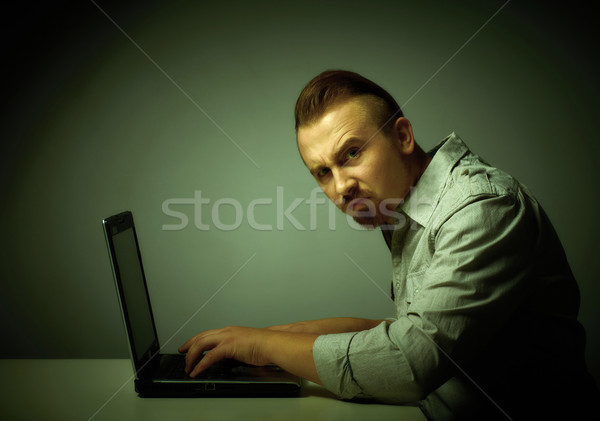 Stock photo: Young dissatisfied man working with laptop.