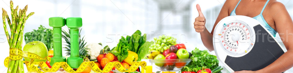 Stock photo: Woman hands with scales and fruits.