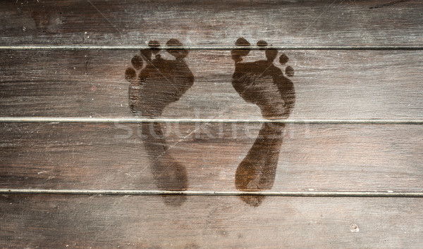 Wet footprints on dark wooden plank floor. Stock photo © kyolshin