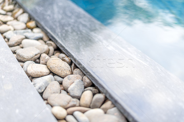 Pool with pebble border framed with stone. Stock photo © kyolshin