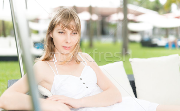 Woman relaxing on sofa on resort outdoor. Stock photo © kyolshin