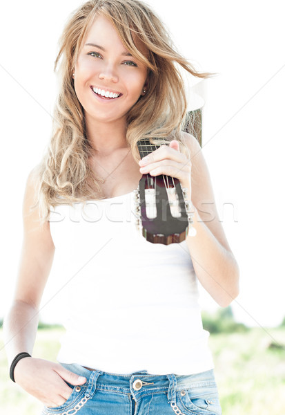 Young woman with guitar and blue sky background. Stock photo © kyolshin