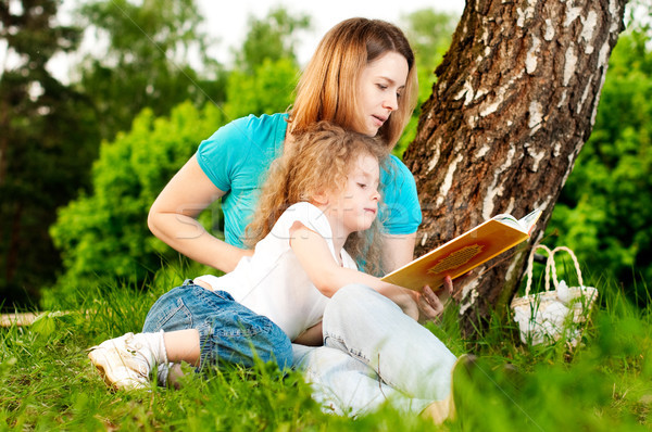 Stock photo: mother reading book to her daughter