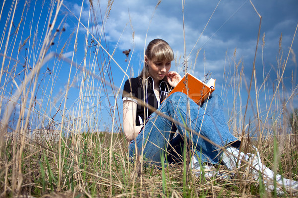 Fată lectură carte şedinţei în aer liber cer Imagine de stoc © kyolshin
