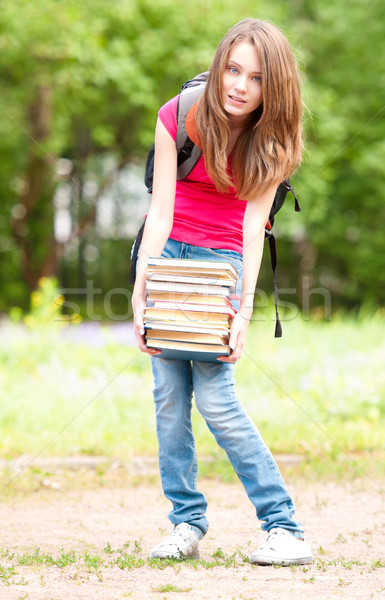 young student girl holding big pile of heavy books Stock photo © kyolshin