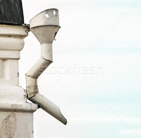 Metal sewer attached to corner of white building. Stock photo © kyolshin