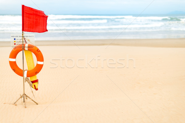 Life saving objects with red flag on beach. Stock photo © kyolshin