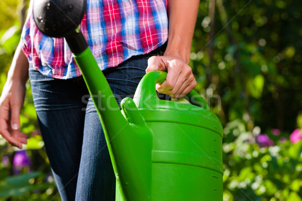 Woman in garden with watering can in hand Stock photo © Kzenon