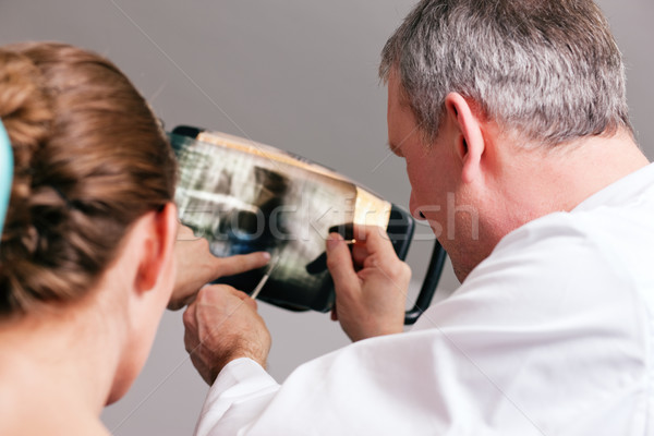 Dentist explaining x-ray to patient Stock photo © Kzenon