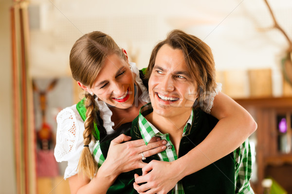 Young couple in traditional Bavarian Tracht in restaurant or pub Stock photo © Kzenon
