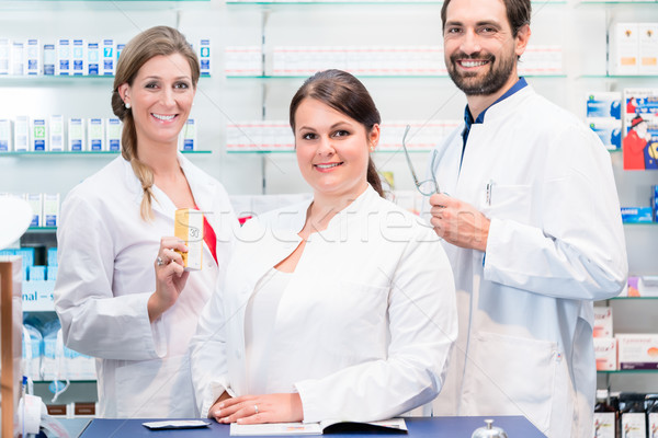 Team of pharmacists in drug store checking pharmaceuticals Stock photo © Kzenon