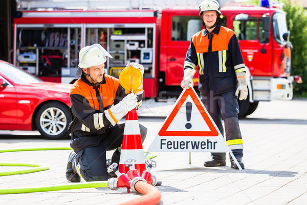 Female fire fighters setting up attention sign Stock photo © Kzenon