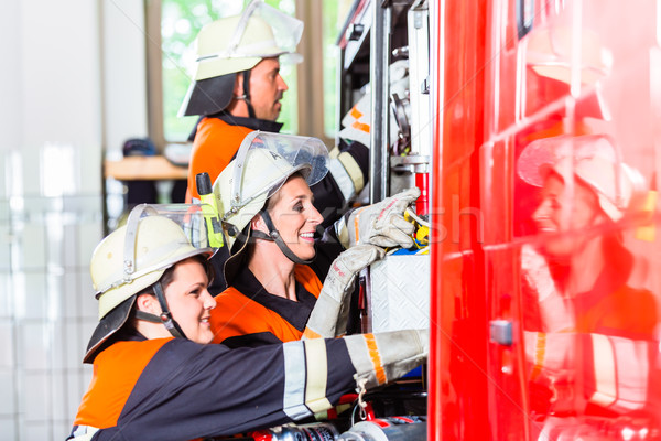 Fire fighters attaching hose at hose laying vehicle Stock photo © Kzenon