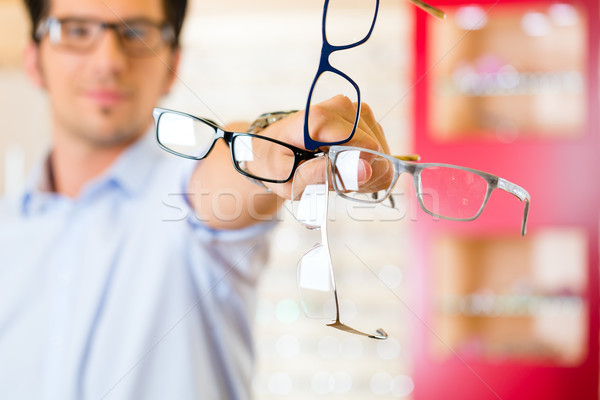 Young man at optician with glasses Stock photo © Kzenon