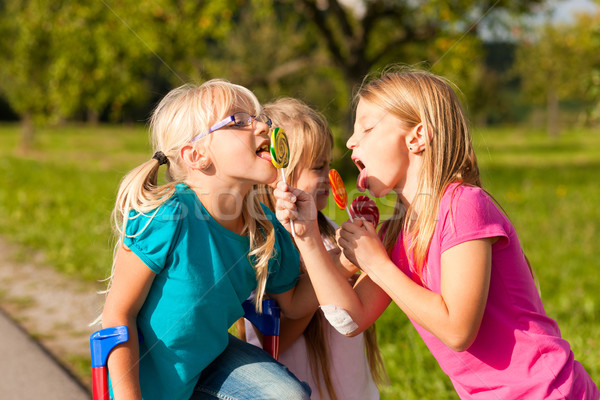 Three girls eating lollypops Stock photo © Kzenon