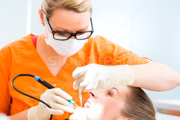 Patient having dental tooth cleaning at dentist Stock photo © Kzenon
