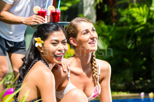 Women in vacation at Asian hotel pool with cocktails Stock photo © Kzenon