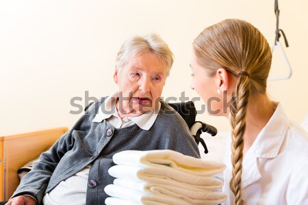 Nurse bringing supplies to woman in retirement home Stock photo © Kzenon