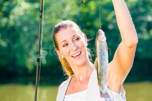 Sport fisherwoman showing her catch  Stock photo © Kzenon