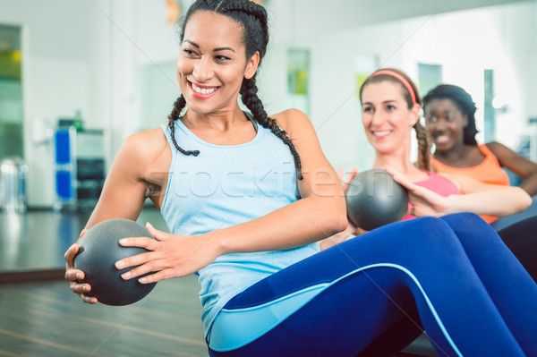 Beautiful woman exercising Russian twist with med ball for strong abs Stock photo © Kzenon