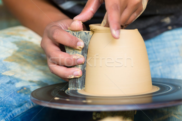 Potter creating clay bowl on turning wheel Stock photo © Kzenon
