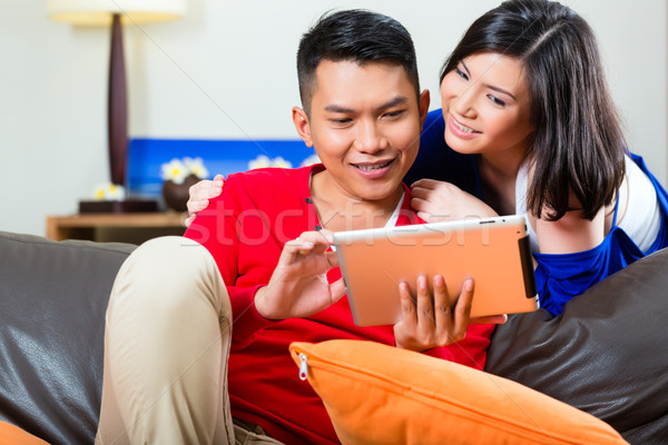 Asian couple on the couch with a tablet pc Stock photo © Kzenon