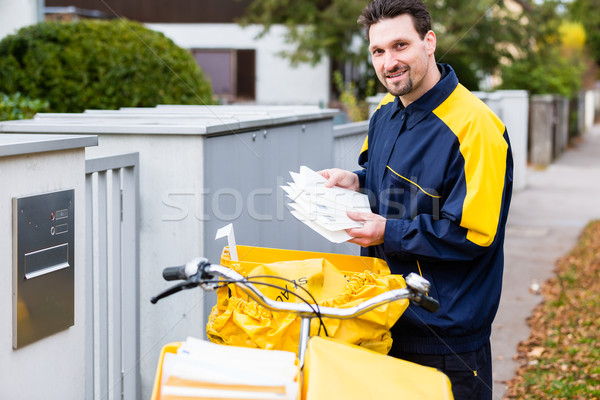 Postman delivering letters to mailbox of recipient Stock photo © Kzenon