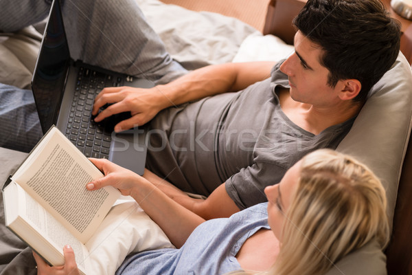 Couple with different hobbies sitting in bed Stock photo © Kzenon