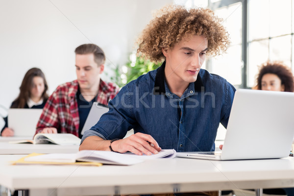 Portrait of a young hard-working student writing during class Stock photo © Kzenon