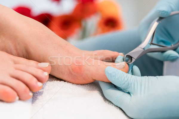 Stock photo: Close-up of the hands of a pedicurist wearing surgical gloves